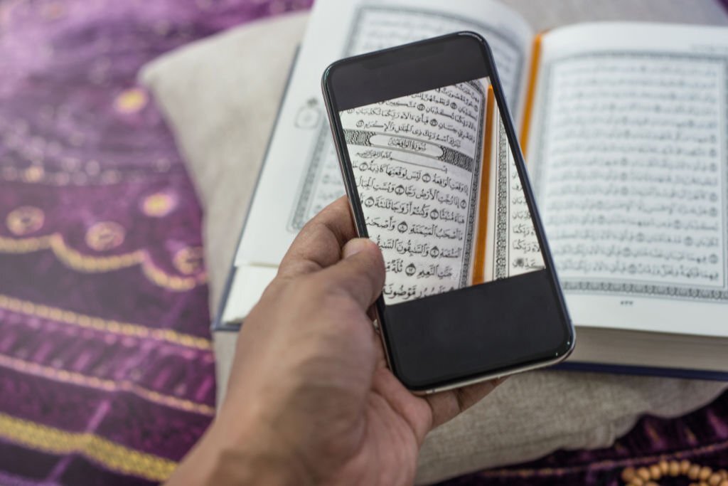 Using camera phone to close up Al-Quran's verse at home during Ramadan
