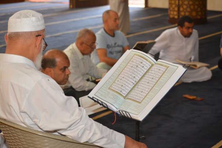 Cairo, Egypt, July 8 2022: A Noble Quran reading ring inside a mosque at the day of Arafah or Arafat before Eid Al-Adha, a group of people reading and learning Quran with an Islamic Imam or preacher