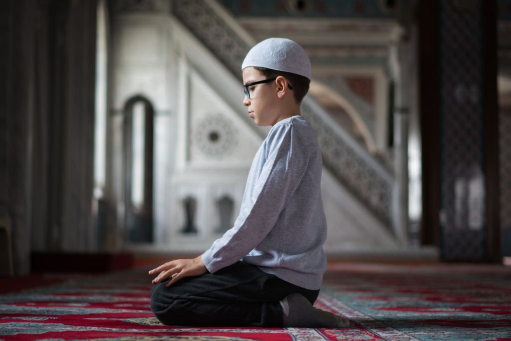 Muslim boy praying in Mosque